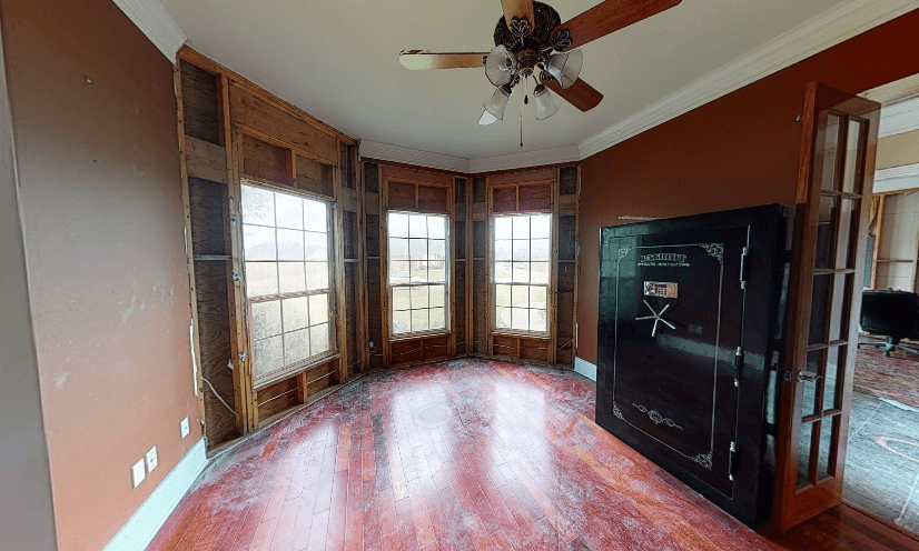 A post-restoration den, with walls and flooring transformed by Quillen Construction Group in New Orleans, after hurricane damage.