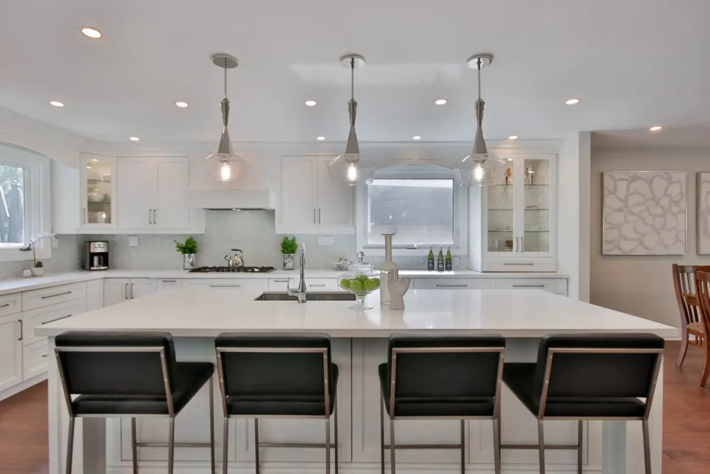 A picture of a newly renovated kitchen with black stools and quartz countertops for the blog "Accessorizing Your Kitchen After a Kitchen Remodel in New Orleans".