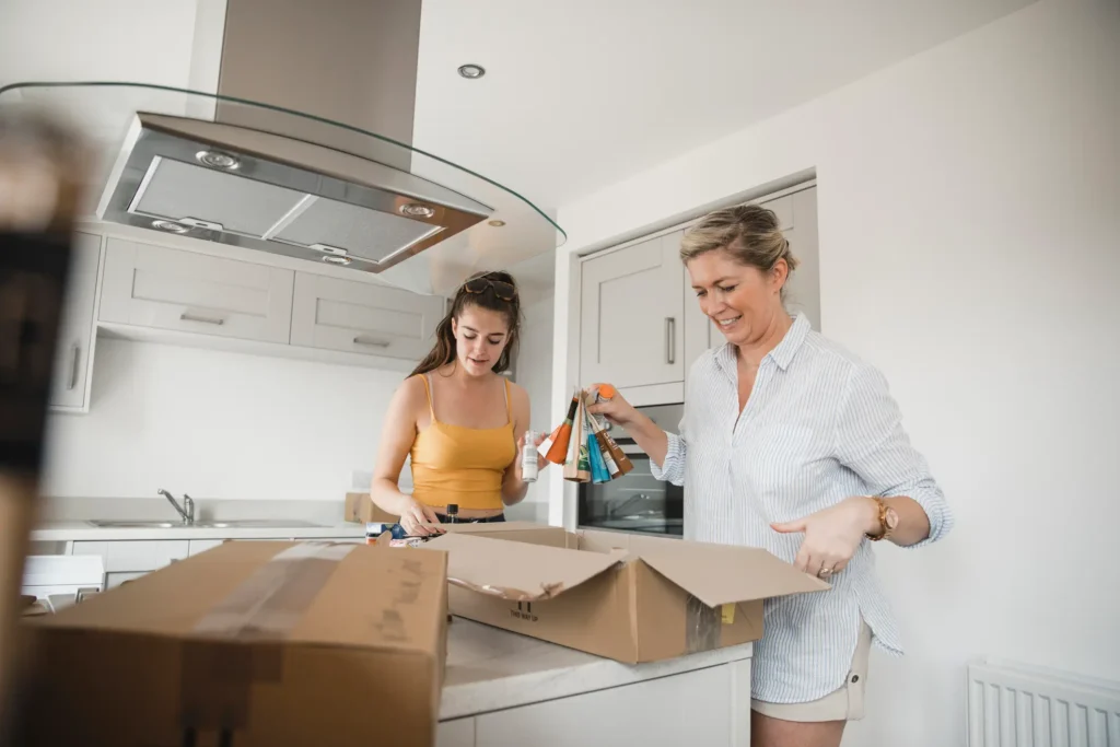 How to Survive a Kitchen Remodel - A picture of a mother and daughter putting kitchen items in a box.