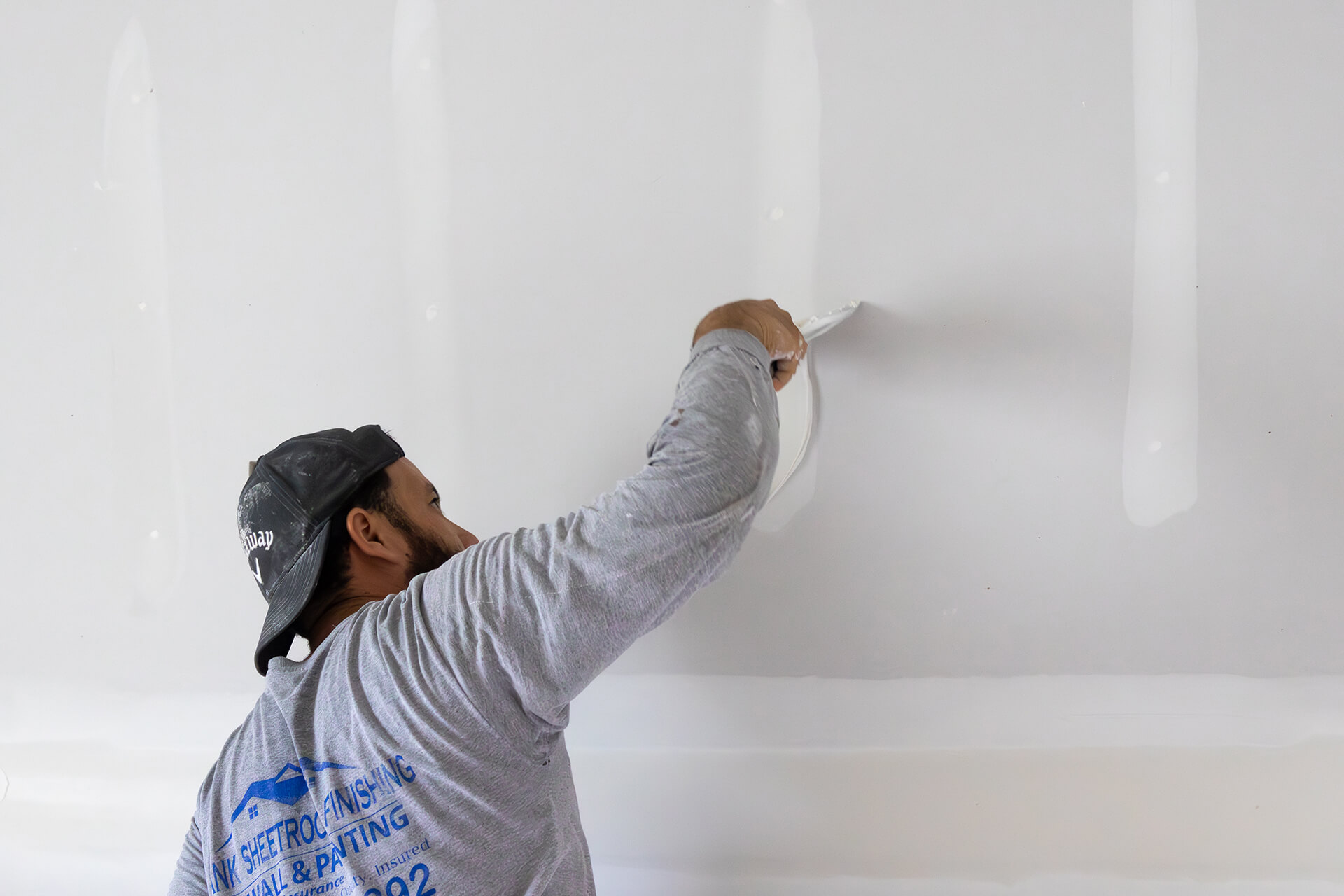 A man painting a wall, showcasing the precision and expertise of a General Contractor New Orleans relies on for quality work.